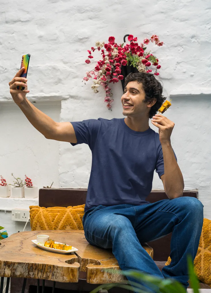mockup-of-a-man-in-a-gildan-tee-taking-a-selfie-of-him-with-a-street-food-snack-m30296 (1).webp