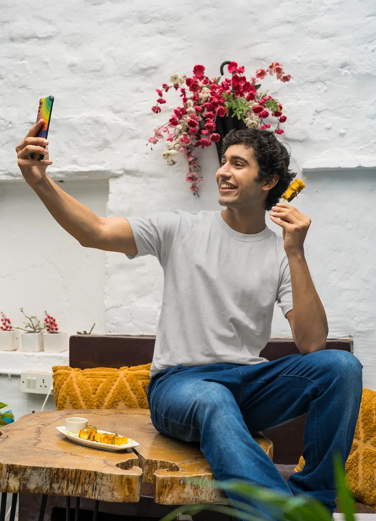 mockup-of-a-man-in-a-gildan-tee-taking-a-selfie-of-him-with-a-street-food-snack-m30296 (2).webp