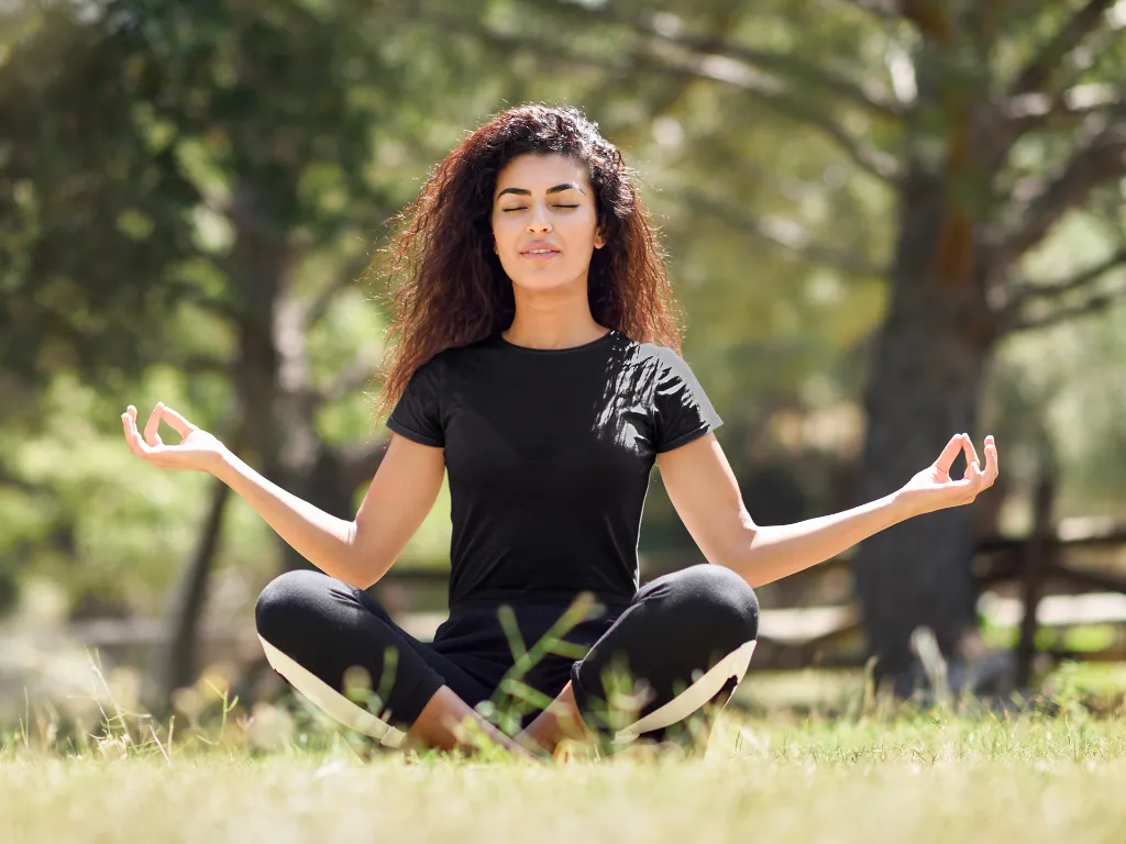 t-shirt-mockup-of-a-young-woman-with-curly-hair-meditating-in-the-park-35285-r-el2 (1).webp